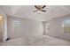 Large bedroom with neutral walls, carpet, and tray ceiling with ceiling fan at 231 Beechwood Ln, Stone Mountain, GA 30087