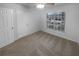 This bedroom features neutral walls and carpet, a ceiling fan, and a window with blinds at 1446 Dunton Green Way, Lawrenceville, GA 30043