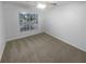 Bright and airy bedroom with a large window and neutral carpet, offering a blank canvas for personalization at 1446 Dunton Green Way, Lawrenceville, GA 30043
