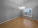 Formal dining room with hardwood floors, chandelier, and large window for ample natural light at 1446 Dunton Green Way, Lawrenceville, GA 30043