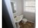 Small bathroom features a classic pedestal sink, standard toilet, and natural light from a window at 2491 Hatfield Cir, Atlanta, GA 30316