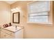 Bathroom with white vanity, mirror, window with blinds, and soft lighting at 335 Old Airport Rd, Carrollton, GA 30116