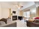 Comfortable living room with a fireplace, ceiling fan, and ample seating, bathed in natural light at 335 Old Airport Rd, Carrollton, GA 30116