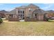 Brick home featuring a spacious backyard and stone patio, perfect for outdoor enjoyment at 1132 Venetian Ln, Hampton, GA 30228