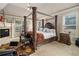 Cozy bedroom with a luxurious canopy bed, fireplace, and neutral decor at 1132 Venetian Ln, Hampton, GA 30228