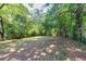 Large, lush backyard space featuring mature trees and a wood fence, perfect for outdoor activities at 1247 Monroe Ne Dr, Atlanta, GA 30306