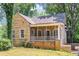 Charming stone home featuring a screened front porch and well-kept lawn at 1247 Monroe Ne Dr, Atlanta, GA 30306