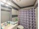 Standard bathroom with a tiled accent wall, shower, and single sink vanity at 2690 Manassas Pl, Snellville, GA 30039