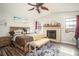 Vaulted ceiling bedroom with wood floors features a fireplace and decorative ceiling fan at 2690 Manassas Pl, Snellville, GA 30039