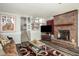 Cozy living room features a brick fireplace and hardwood flooring, stairs, and a view to the kitchen at 2690 Manassas Pl, Snellville, GA 30039