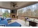 Relaxing covered porch with a brick fireplace, TV, ceiling fan, and outdoor seating at 4070 Preserve Crossing Ln, Cumming, GA 30040
