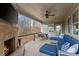 Relaxing covered porch with a brick fireplace, TV, ceiling fan, and outdoor seating at 4070 Preserve Crossing Ln, Cumming, GA 30040