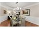 Elegant dining room with a glass table, modern chandelier, and wainscoting at 4070 Preserve Crossing Ln, Cumming, GA 30040