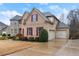 Traditional brick home with red shutters, a well-manicured lawn, and a two-car garage at 4070 Preserve Crossing Ln, Cumming, GA 30040