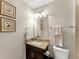 Stylish powder room features a granite countertop, decorative mirror, and wall art at 4070 Preserve Crossing Ln, Cumming, GA 30040
