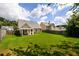 Spacious backyard with lush green grass, a covered patio, and fencing at 260 Shadowbrooke Dr, Loganville, GA 30052