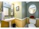 The powder room features a pedestal sink and decorative wall mirror at 260 Shadowbrooke Dr, Loganville, GA 30052