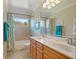 Bathroom featuring double sinks, wood cabinets, and shower-over-tub with decorative curtains at 351 Allendale Dr, Canton, GA 30115