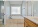 Bright bathroom with a large soaking tub, glass block window, and tiled floors at 351 Allendale Dr, Canton, GA 30115