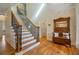 Elegant foyer with hardwood floors, staircase, and a vintage bench with mirror and coat rack at 351 Allendale Dr, Canton, GA 30115