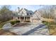 Stunning two-story home with stone and siding, features a circular driveway, mature trees and landscaping at 351 Allendale Dr, Canton, GA 30115