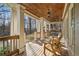 Inviting covered front porch, features natural wood decking and trim, classic white columns, and a peaceful outdoor seating area at 351 Allendale Dr, Canton, GA 30115