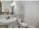 Half bath featuring a pedestal sink, decorative mirror, and wood flooring at 351 Allendale Dr, Canton, GA 30115