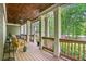 Beautiful side porch with wooden floors, stylish white columns, railings, cozy seating, and lush greenery at 351 Allendale Dr, Canton, GA 30115