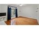 Hardwood bedroom with large window dressed with blue curtains and adjacent shelving and storage at 4125 Gables Pl, Buford, GA 30519