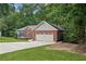 A single-Gathering home has a two-car garage, a lawn, and many trees surrounding the home at 4125 Gables Pl, Buford, GA 30519