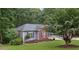A single-Gathering home with a brick and vinyl exterior is surrounded by trees and a well-manicured lawn at 4125 Gables Pl, Buford, GA 30519