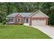 Charming single-Gathering home with brick accents, two-car garage, and a well-manicured lawn and mature trees at 4125 Gables Pl, Buford, GA 30519