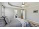 Spacious bedroom boasts a trey ceiling, ceiling fan, and neutral color palette with connecting bathroom at 4125 Gables Pl, Buford, GA 30519