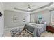 Serene main bedroom with tray ceiling, ceiling fan and a cozy decor with a view to the exterior at 4125 Gables Pl, Buford, GA 30519