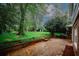 Backyard brick patio with a lush lawn and mature trees, perfect for outdoor entertaining or relaxing in a serene setting at 4144 Hideaway Dr, Tucker, GA 30084
