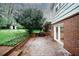 Backyard brick patio with a lush lawn and mature trees, perfect for outdoor entertaining or relaxing in a serene setting at 4144 Hideaway Dr, Tucker, GA 30084
