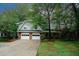 Charming two-story home features a brick facade, attached two-car garage and a well-manicured front lawn with mature trees at 4144 Hideaway Dr, Tucker, GA 30084