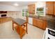 Well-lit kitchen offers granite countertops, wood cabinetry, stainless sink, and open concept to living room at 4144 Hideaway Dr, Tucker, GA 30084