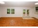 Large living room with wood floors, window, and French doors offering natural light and seamless access to the outdoors at 4144 Hideaway Dr, Tucker, GA 30084