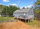 Backyard view of a gray two-story home featuring a spacious wooden deck at 113 Emerald Pines Dr, Dallas, GA 30157