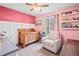 Cozy Bedroom with a crib, chair, and shelves filled with books, creating a peaceful and organized space at 113 Emerald Pines Dr, Dallas, GA 30157