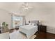 Bright main bedroom featuring hardwood floors, a ceiling fan, and backyard views at 2427 Millbank Ct, Lawrenceville, GA 30043