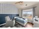 Cozy bedroom featuring stylish wainscoting, patterned wallpaper, and a large window at 2427 Millbank Ct, Lawrenceville, GA 30043