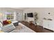 Cozy living room features hardwood floors, a gray sofa, and large windows for natural light, creating a welcoming atmosphere at 2427 Millbank Ct, Lawrenceville, GA 30043