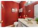 Stylish half-bathroom boasts unique red walls, modern sink, and whimsical decor, creating a memorable space at 917 Edgewater Cir, Marietta, GA 30062