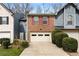 Brick townhome featuring a two-car garage, red shutters, and neatly trimmed landscaping for a welcoming curb appeal at 917 Edgewater Cir, Marietta, GA 30062