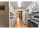 Galley kitchen features white cabinets and appliances, wood floors, and flows into adjacent dining area with outdoor deck at 917 Edgewater Cir, Marietta, GA 30062