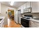 Efficient kitchen with white cabinetry and appliances, adjacent to the dining area and a glimpse of the backyard at 917 Edgewater Cir, Marietta, GA 30062