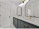 Bright bathroom featuring double vanities, black framed mirrors, and modern lighting at 1303 Angel Falls Sw Ln, Atlanta, GA 30311