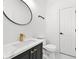 Bathroom vanity with modern fixtures, round mirror and custom black cabinets at 1303 Angel Falls Sw Ln, Atlanta, GA 30311